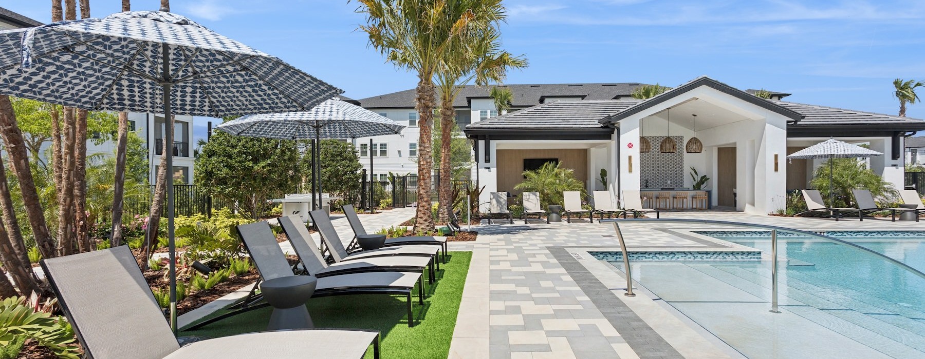a swimming pool with lounge chairs and umbrellas
